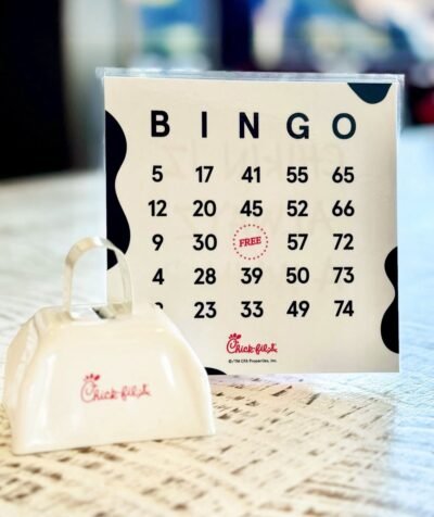 Bingo card with Chick-fil-A logo on a table with a white bingo stamp set in front